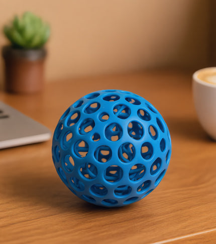 Relaxing desk setup featuring a 3D-printed stress-relief toy with soft, organic shapes, ergonomic design, and a minimalistic background. The workspace has a warm, inviting atmosphere with calming colors.